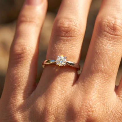 Close-up of a gold solitaire engagement ring on the ring finger, with a sparkling diamond catching the light,