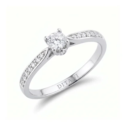 Engagement ring with a solitaire diamond and pavé diamonds along the white metal band, held by prongs.
