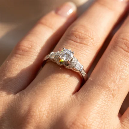 Diamond engagement ring with a large central stone and pavé band on a finger, sparkle visible in sunlight.