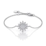 Silver bracelet with a sunburst diamond centerpiece on a white background.