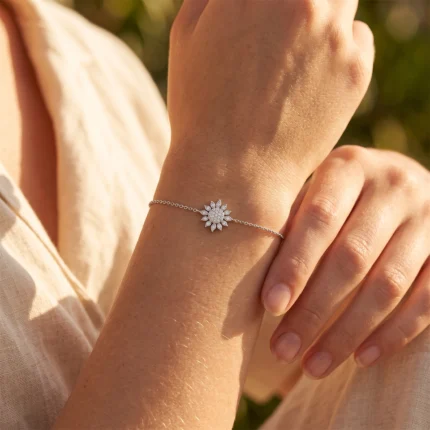 Bracelet with a sunburst centerpiece encrusted with small diamonds on a woman's wrist in sunlight
