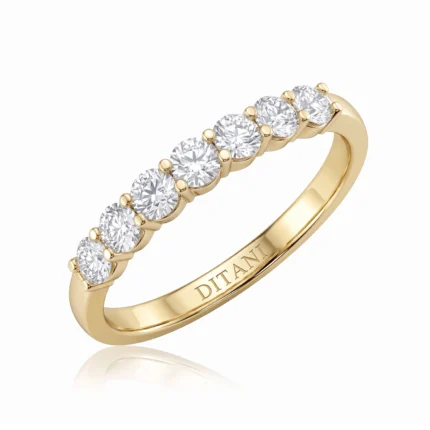 Yellow gold ring with seven round diamonds prong-set along the top; DITANI engraved on the inner band.