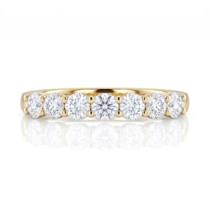 Gold ring with seven round diamonds set along the band in a polished finish.