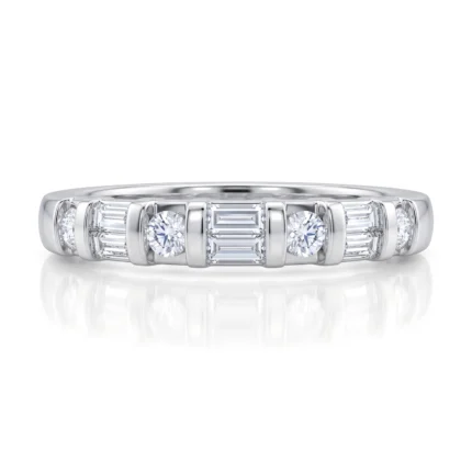 Ring with a row of alternating round and baguette-cut diamonds set in white metal, likely platinum or white gold, on a reflective surface