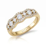 Gold ring with three large central diamonds and a pavé halo of smaller diamonds along a curved band, inner inscription visible.