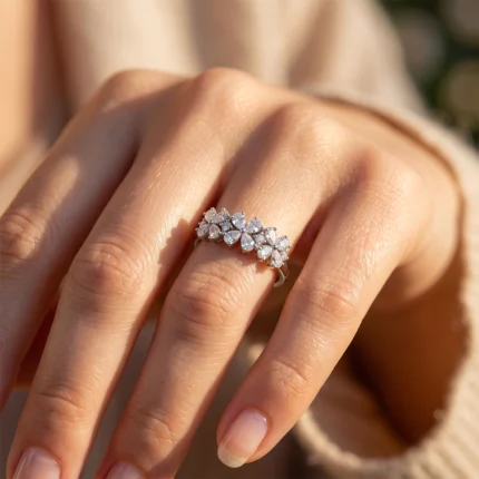Close-up of a hand wearing a silver floral diamond ring on the ring finger