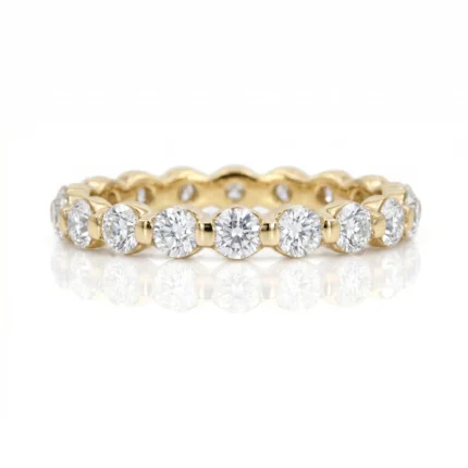 Gold eternity band with alternating round-cut diamonds in bezel settings around a yellow-gold ring
