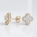 Gold stud earrings in a four-leaf clover shape set with diamonds, front view.