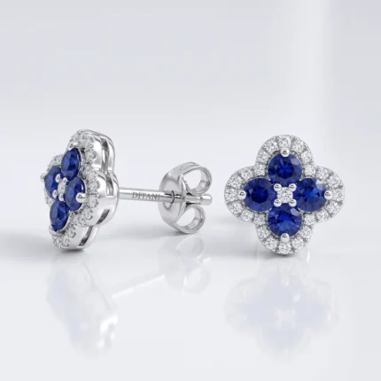 Silver stud earrings featuring blue sapphire flowers surrounded by diamonds on a white background, with butterfly-style backing visible.
