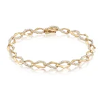Gold bracelet with diamond-studded links on a white background, showing a polished clasp edge of the chain