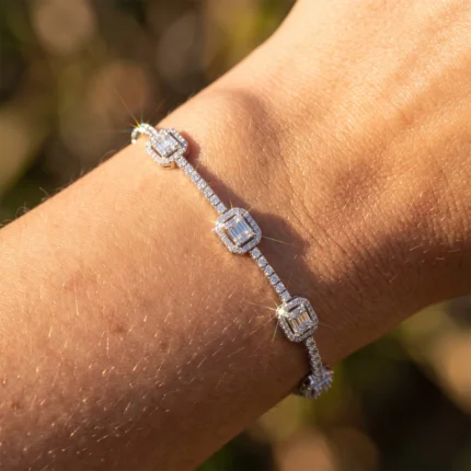 Close-up of a diamond bracelet on a sunlit wrist, featuring square-cut stones connected by pavé settings.