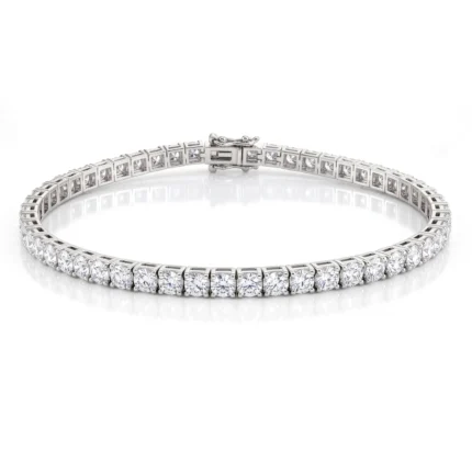 Diamond tennis bracelet in white metal with a continuous row of diamonds on a curved band, against a white background.