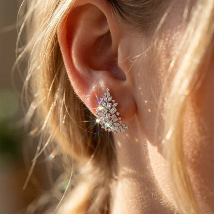 Close-up of a woman's ear with a sparkling diamond-leaf earring.