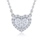 Heart-shaped pendant necklace with a large central diamond surrounded by smaller pavé diamonds on a silver chain