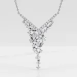 Diamond-encrusted V-shaped pendant with a cascading cluster of stones on a silver necklace