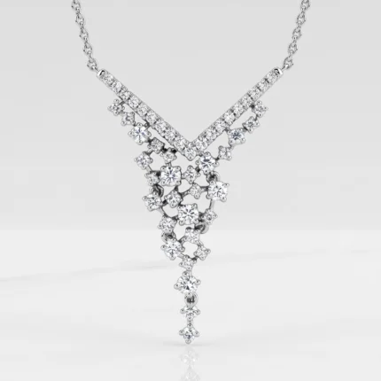 Diamond-encrusted V-shaped pendant with a cascading cluster of stones on a silver necklace