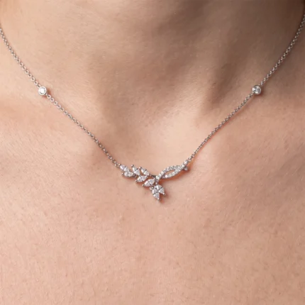Silver chain necklace with a diamond-encrusted leaf-style pendant resting on the neck.