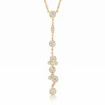 Gold necklace with a delicate vertical drop featuring several diamond-studded circles along a fine chain
