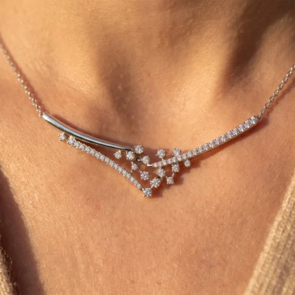 Diamond necklace with a curved silver bar and diamond-studded vine resting on a woman’s neck.