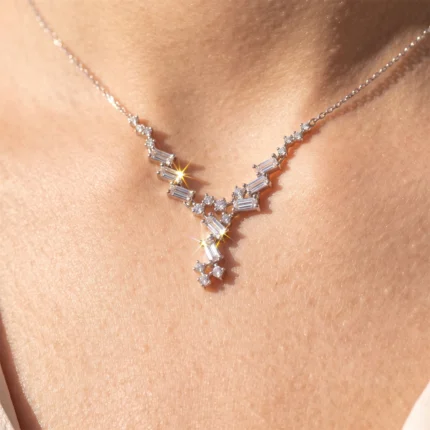 Diamond necklace with a V/Y-shaped pendant resting on skin, sparkling with small round and baguette-cut stones.