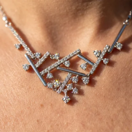 Close-up of a silver diamond necklace resting on bare skin.