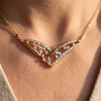 Close-up of a gold necklace with two diamond-studded chevron pendants resting on a woman's neck.