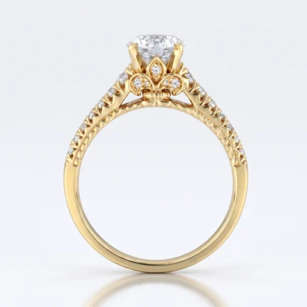 Yellow-gold engagement ring with a large central diamond and pavé diamonds along the shoulders in an ornate fleur-de-lis design.