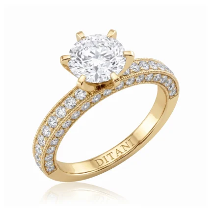 Gold engagement ring with a large round diamond in a six-prong setting and pavé diamonds along the twin-band with milgrain edges.