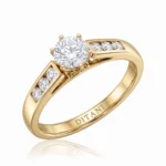 Gold ring with a large round central diamond and smaller diamonds set along the band, engraved DITANI inside.