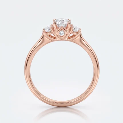 Rose gold engagement ring with a central diamond flanked by two side stones in a crown-style setting on a smooth band