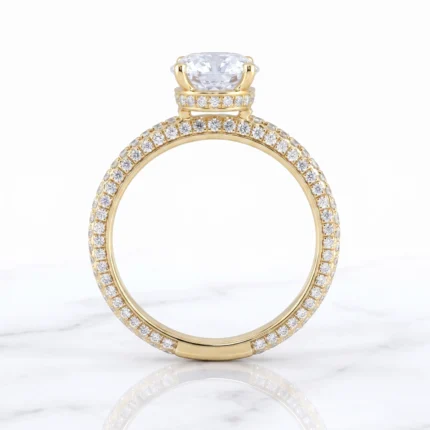 Gold solitaire engagement ring with a large cushion-cut center diamond and diamond-studded band and setting.