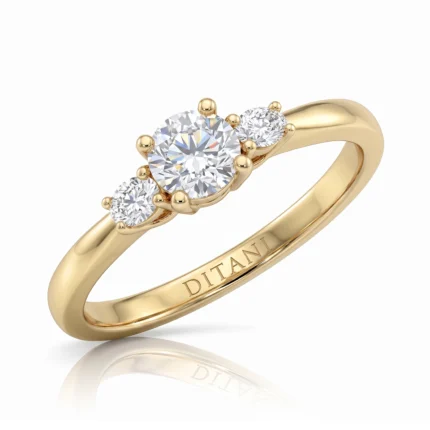 Gold ring with a large center diamond and two smaller side diamonds set in a yellow-gold band.