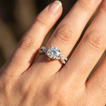 Close-up of a hand wearing a diamond engagement ring with a round center stone and pavé-band design on a two-tone setting.