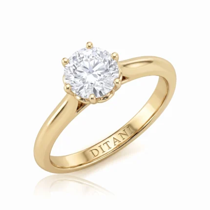Gold solitaire engagement ring with a round diamond set in four-prong head, band engraved DITANI