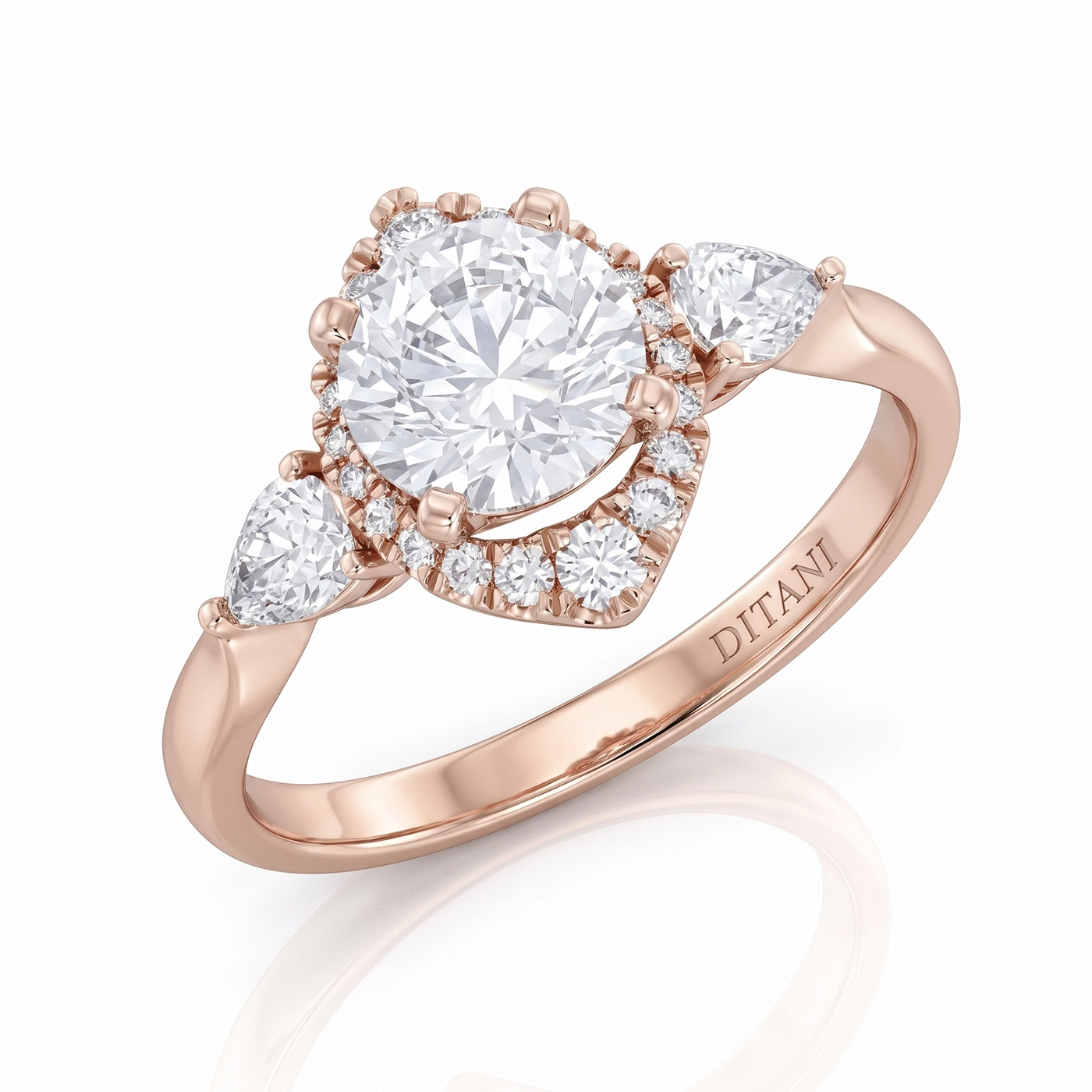 Годежен пръстен с диамант DITANI 2 - DITANI Rose gold ring with a large round center diamond, diamond halo, and pear-shaped side stones; DITANI engraved on the band.