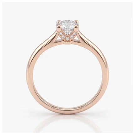 Rose gold engagement ring with a central round diamond held by prongs and small pavé diamonds along the setting.