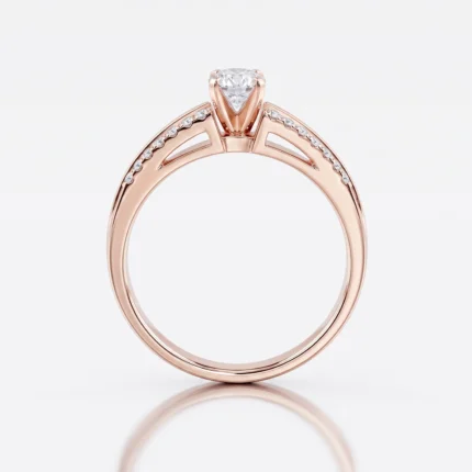 Rose gold engagement ring with a pear-shaped center diamond and pavé diamonds along the band on the shoulders of the ring.
