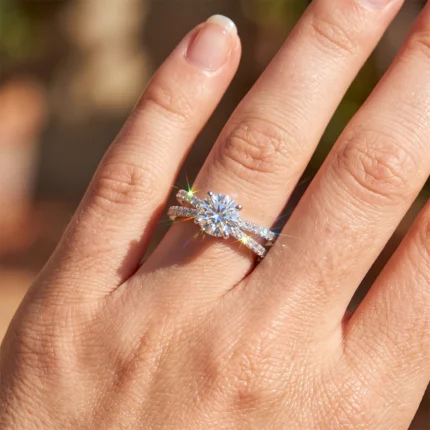 Close-up of a diamond engagement ring on the ring finger featuring a large center stone and pavé bands catching sunlight.