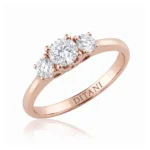 Rose gold ring with three round diamonds in a shared-prong setting, band engraved 'DITANI' on the side.