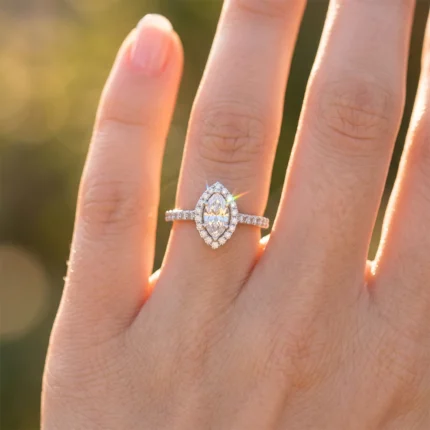 Close-up of a pear-cut diamond engagement ring with a halo of smaller stones on the ring finger.