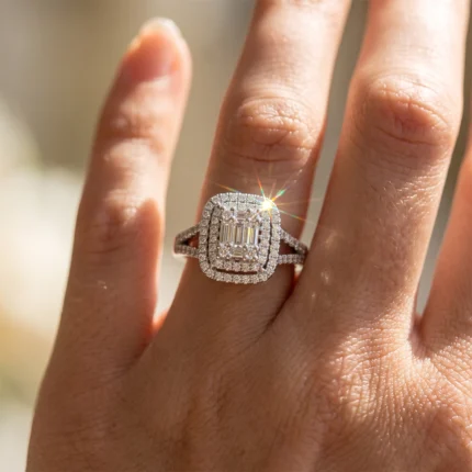 Close-up of a sparkling diamond halo ring on a finger, sunlight creating a starburst sparkle on the gems.