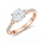 Rose gold engagement ring with a large round center diamond and smaller diamonds along the band.