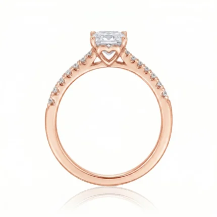 Rose gold engagement ring with a large square-cut center diamond and pavé diamonds along the band, heart-shaped detail beneath the setting.