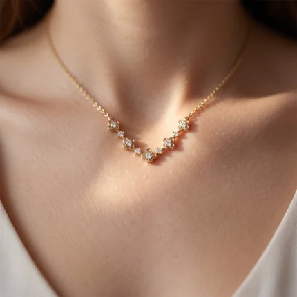 Gold necklace with small diamond-like stones arranged in flower-shaped links along a delicate chain on the neck.