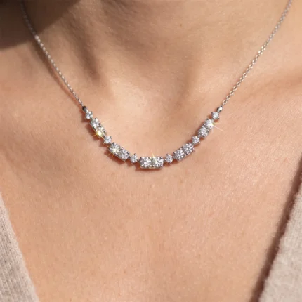 Diamond tennis necklace on a woman's collarbone with alternating square and round stones and a delicate silver chain.