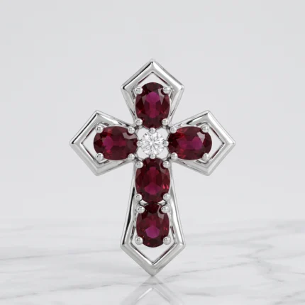 Silver cross pendant with five red gemstones arranged at the ends and a central clear diamond, set in square-shaped frames on a pale background