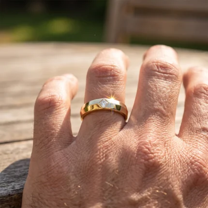 Close-up of a gold ring with a square diamond on the ring finger, sun sparkle on the gem.