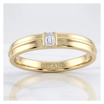 Gold ring with a small emerald-cut diamond center stone, polished yellow gold band and 'DITANI' engraving inside.
