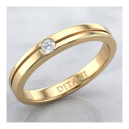 Gold band with a small round diamond set in a bezel, inner engraving visible along the inner edge.