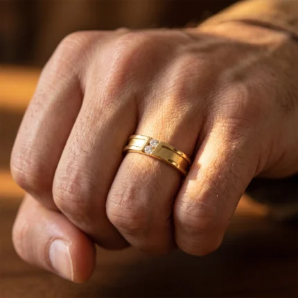 Close-up of a hand wearing two gold rings, one with a small diamond accent on the ring finger